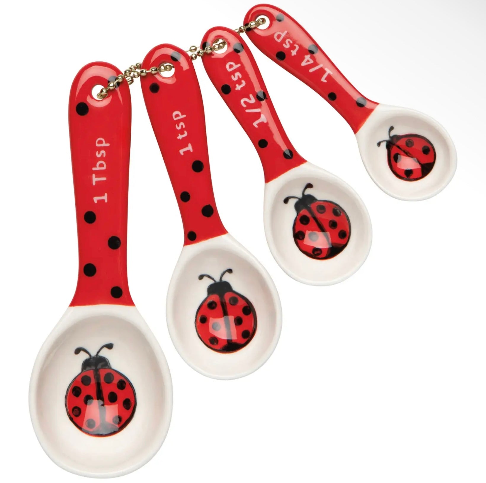 Set of four red and white measuring spoons with a ladybug design in the interior of the spoons. The handles are red with black polka dots, resembling a ladybug pattern. 