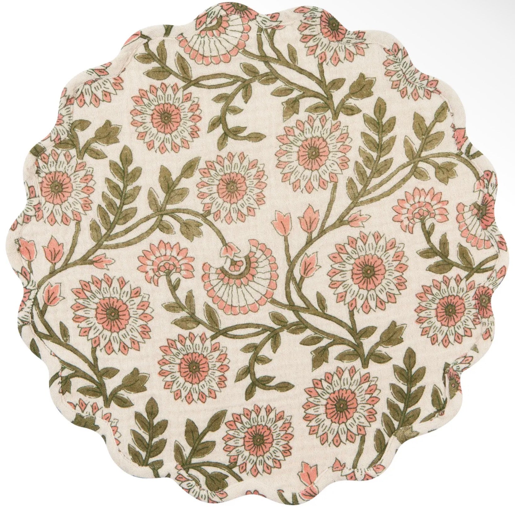 A round fabric placemat with a scalloped edge, featuring a vintage floral pattern in dusty pink and olive green on a cream background.